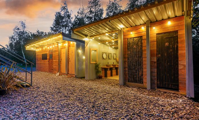 Rustic stylish and eco showers and washing facilities, festoon lights in twilight